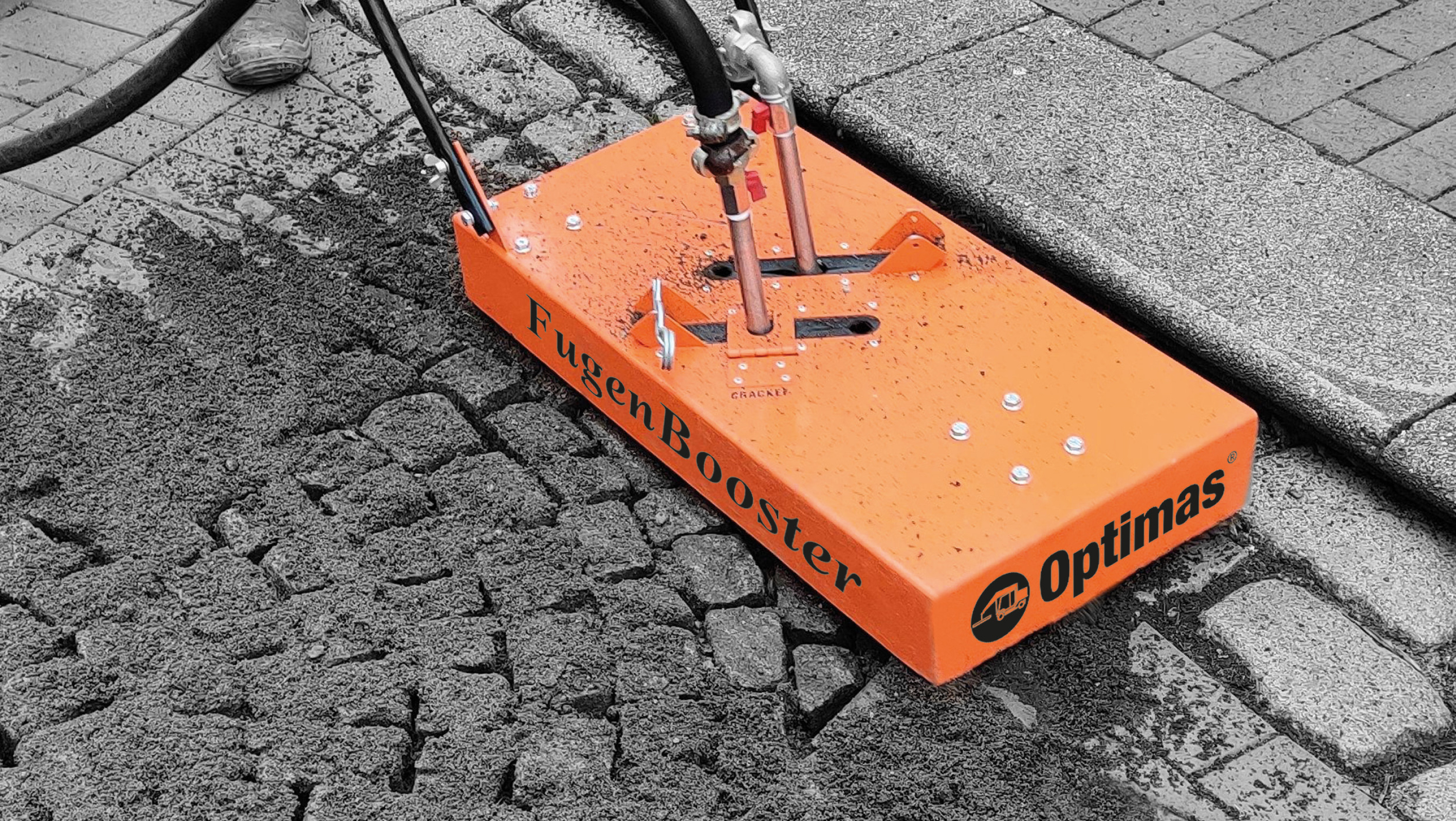 A FugenBooster machine is applying material to cobblestone pavement, enhancing surface durability – Optimas.