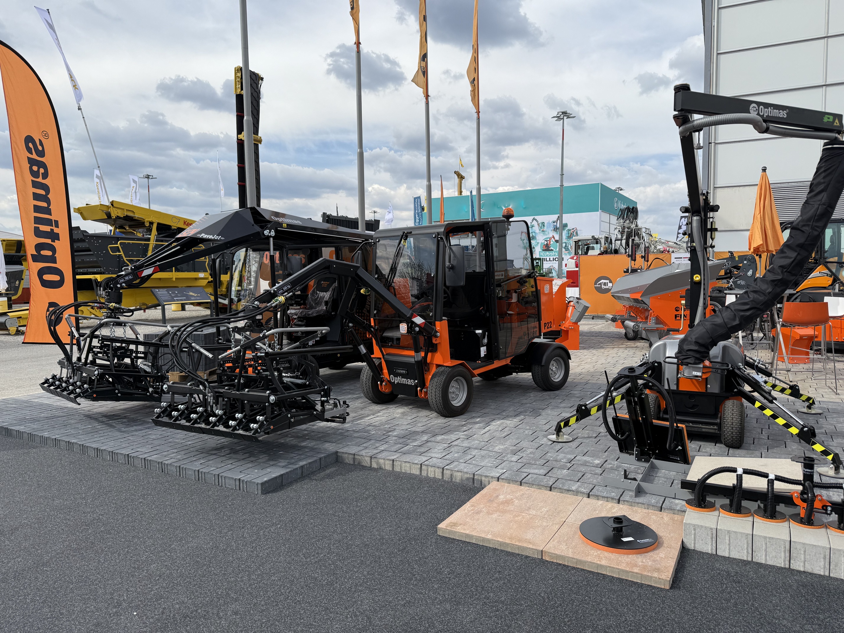 Optimas-Pflastermaschinen auf einer Outdoor-Messe auf gepflastertem Boden und stellen ihre innovative Technologie und ihr Design für effiziente Pflasterarbeiten vor – Optimas.