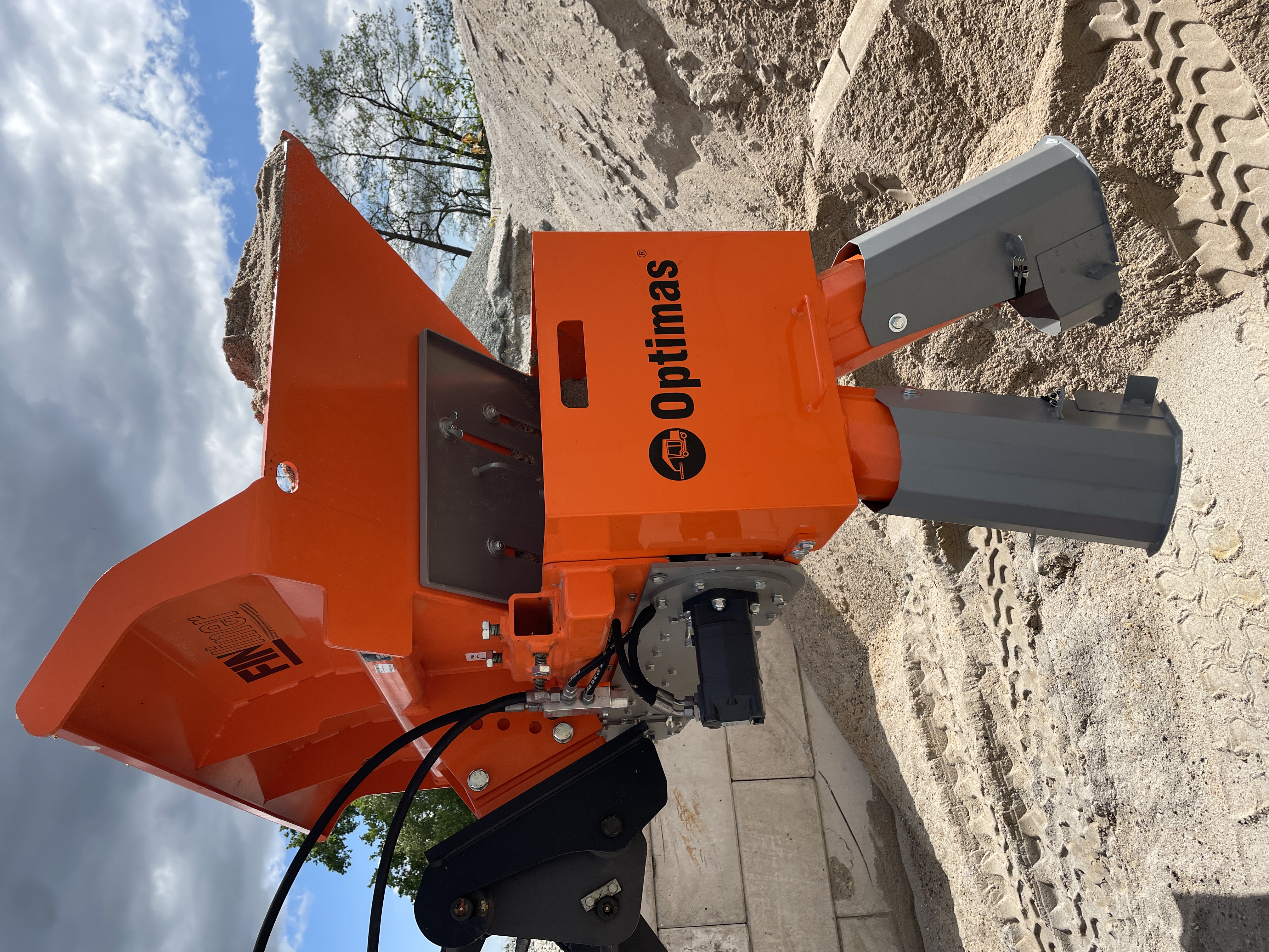 Close-up of an orange sand hopper with a gray discharge chute, designed for construction use – Optimas.