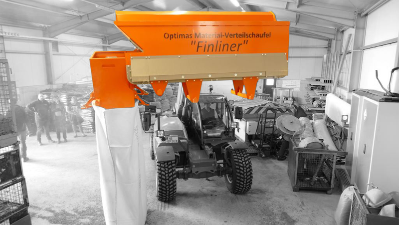Material distribution bucket "Finliner" from Optimas in action, dispensing into a bag. The image showcases precision and efficiency – Optimas.