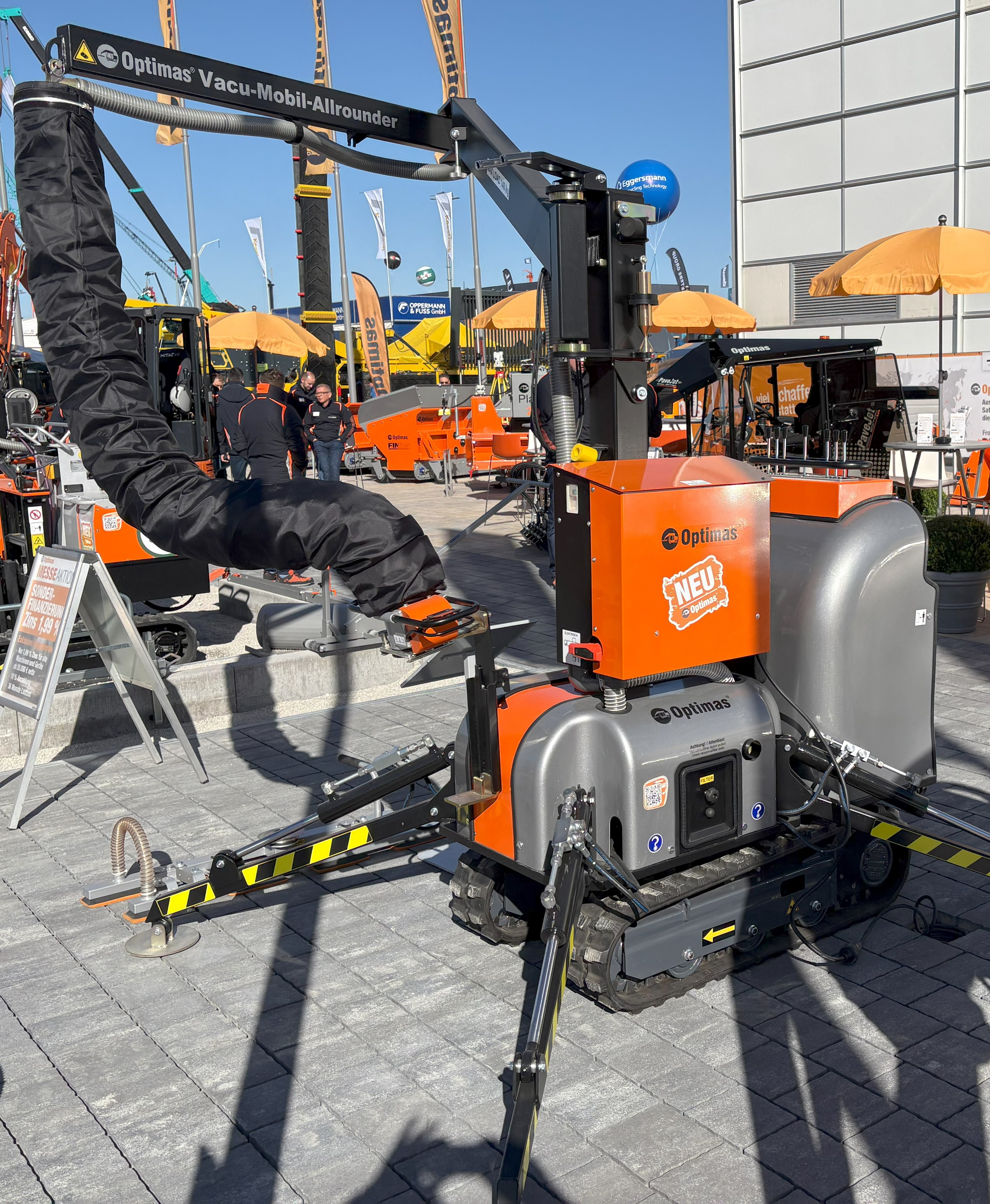 Nahaufnahme einer Optimas Vacu-Mobil-Allrounder-Fertigerverlegemaschine, die ihre Manövrierfähigkeit und ihr innovatives Design auf einer Außenausstellung – Optimas – demonstriert.